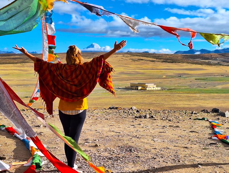 Frau betet Mt. Kailash an. Flatternde Gebetsfahnen